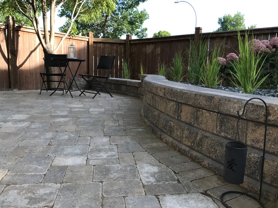 Paving stone patio with a block retaining wall and garden bed