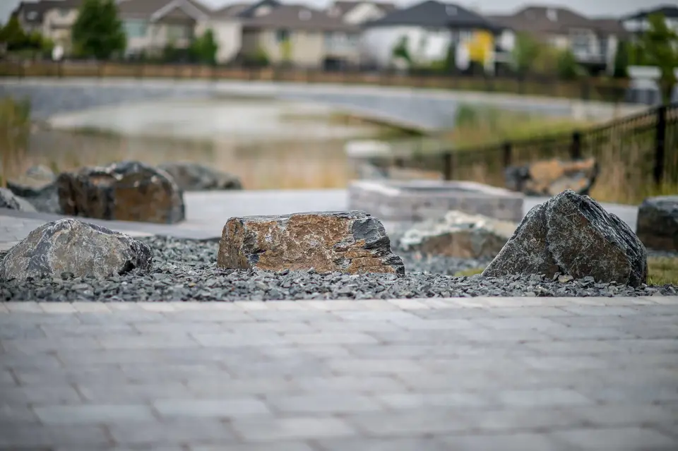 Paver patio edged with boulders and rock