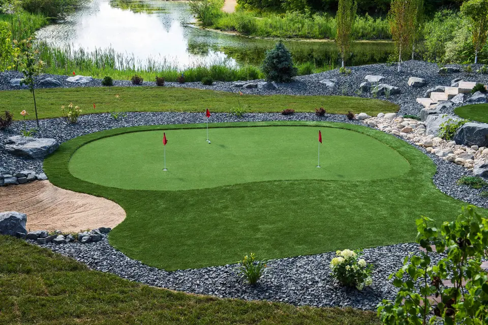 Artificial turf putting green surrounded by decorative rock