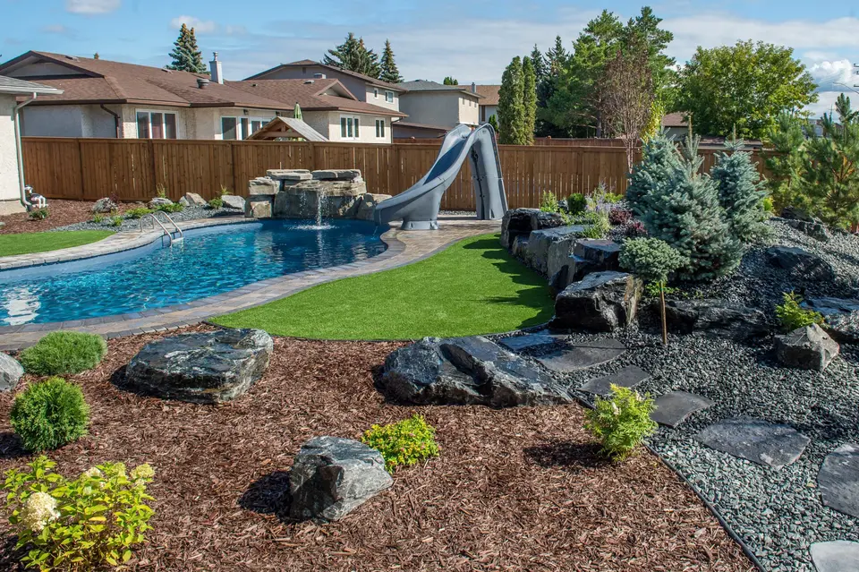 Pool landscape with garden beds, boulders and mulch